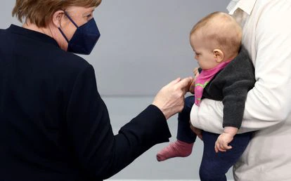 La excanciller Angela Merkel saluda a un bebé durante la asamblea federal para reelegir presidente a Frank-Walter Steinmeier.