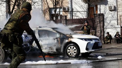 Un coche de policía arde delante de un cuartel en Kiev en la tercera jornada de ataques rusos a la capital de Ucrania. 