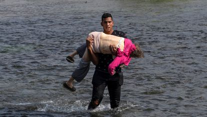 Un migrante venezolano carga una mujer para cruzar el Río Bravo en Coahuila, México.