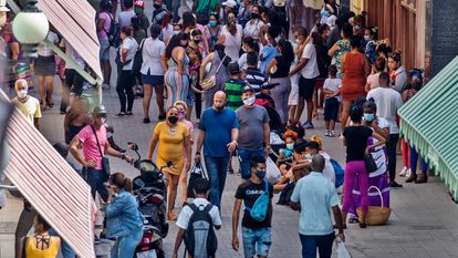 Varias personas caminan para entrar a tiendas en la calle Obispo, el viernes 28 de enero del 2022, en La Habana, Cuba.