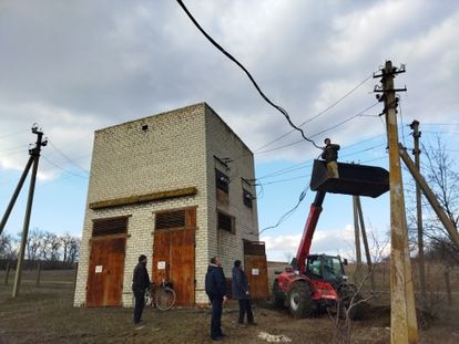 En el pueblo de Krasnogorivka se ha ido la luz por los bombardeos. Un grupo de vecinos trata de arreglar por sus propios medios un transformador.