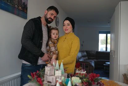 Reham Ghafarji posa junto a su familia y algunos productos cosméticos de su negocio.
