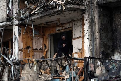 Un hombre observa desde el interior de un edificio de 10 plantas atacado en la madrugada del viernes en Kiev.