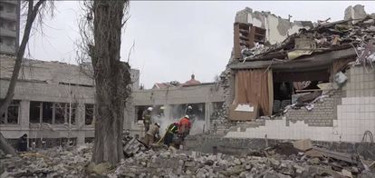 Trabajadores retiran los escombros de un colegio destruido por los bombardeos en Ucrania
