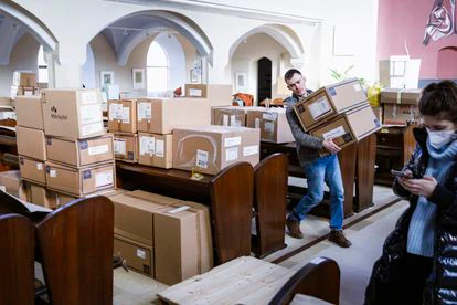 Un voluntario carga en la parroquia de Philippus-Nathanael, en Berlín, cajas de material médico que Oleksii y Thomas van a llevar hasta la frontera de Polonia con Ukrania con un coche y una furgoneta. 