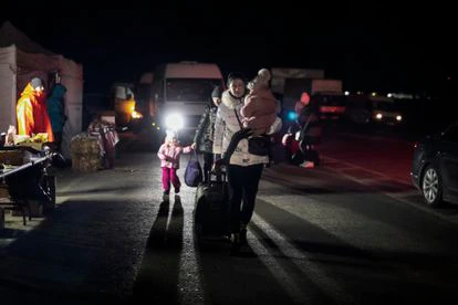 Una familia ucrania se acerca al punto fronterizo de Dolhobyczow-Uhryniv para cruzar a Polonia.