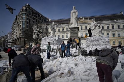 Decenas de voluntarios cubren con sacos de arena el monumento a la princesa Olga en el centro de Kiev para protegerlo de posibles ataques rusos