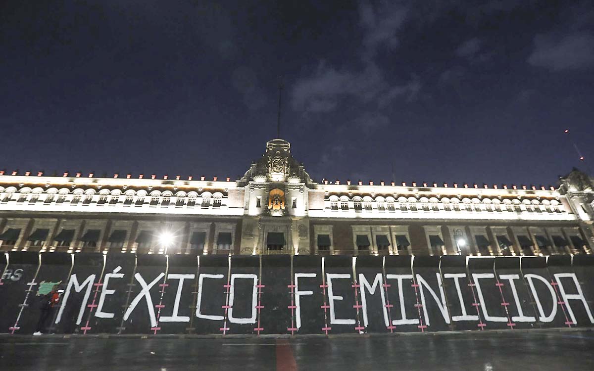 8M: Mujeres escriben ‘México feminicida’ en vallas de Palacio Nacional