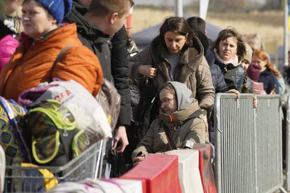 Refugiados ucranios esperan un transporte tras alcanzar el paso fronterizo de Medika en Polonia.