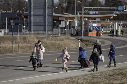 Refugiados ucranios en el lado polaco del paso fronterizo de Budomierz, este domingo.