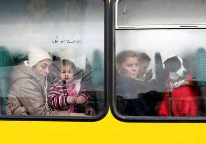 Cientos de personas intentan abandonar Ucrania, en tren y autobús, desde la estación central de Lviv, este domingo.