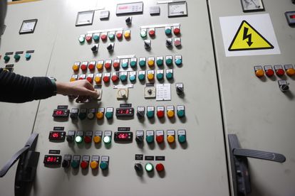 Un hombre controla un panel de electricidad.