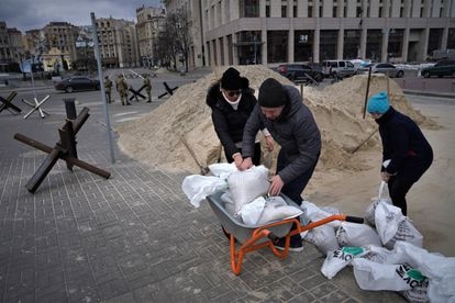 Un grupo de civiles prepara sacos terreros para construir barricadas en Kiev.  