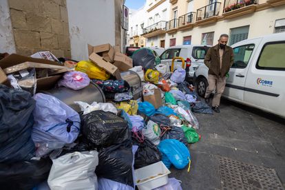 Un vecino de El Puerto pasa junto a la basura acumulada junto al mercado de abastos de la ciudad el pasado 7 de marzo, día en el que se desconvocó la huelga tras 11 días de paro.
