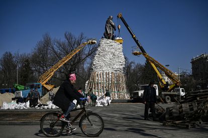 Unos funcionarios usaban sacos de arena para proteger un monumento, este sábado en Járkov.