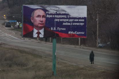 Una transeúnte, ante un cartel que retrata a Putin en Simferopol, Crimea.