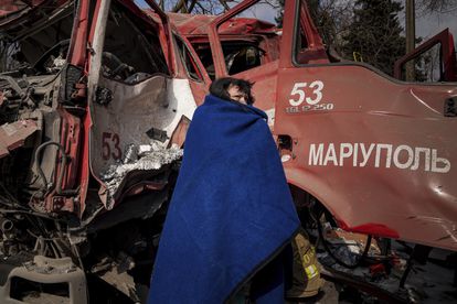 Una mujer se cubre con una manta cerca de un camión de bomberos tras un bombardeo en Mariupol, este jueves.