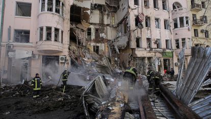 Unos bomberos tratan de apagar un incendio en un edificio golpeado por un proyectil ruso, este lunes en Járkov.