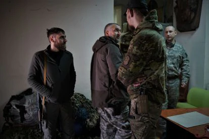 Andrei (en el centro), un médico apodado 'El Filósofo' y comandante del Batallón Azov, junto a varios milicianos en una base de este movimiento en Kiev.