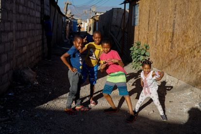 Un grupo de niños haitianos juega por las calles del campamento Nuevo Amanecer de Cerrillos, en Santiago de Chile, donde viven más de 2.000 familias y cerca de 10.000 personas.