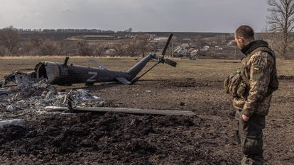 Un soldado ucranio contemplaba el jueves un helicóptero ruso destruido cerca de Járkov.