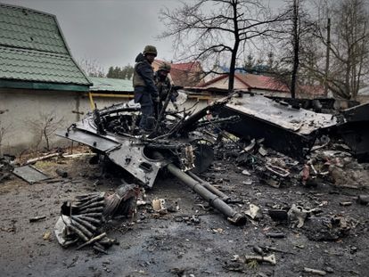 Militares de Ucrania retiran restos de proyectiles y armamento de un tanque ruso tras la batalla en la localidad de Irpin, a las puertas de Kiev. 
