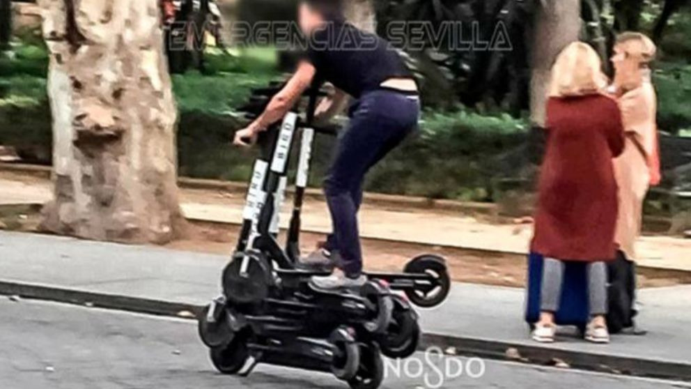 Un hombre conduce sobre seis patinetes eléctricos en Sevilla