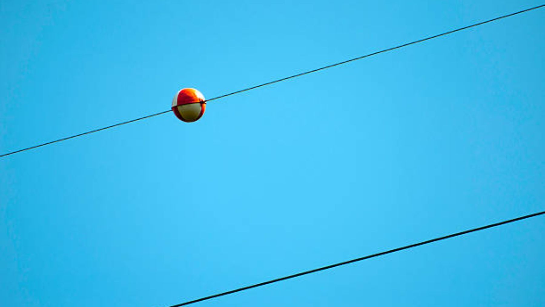 te contamos qué son las bolas rojas que hay en los cables de electricidad