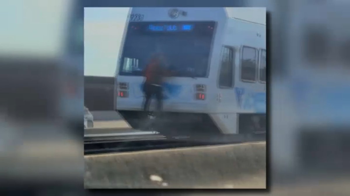 hombre se aferra a la parte trasera de un tren del VTA en movimiento en San José