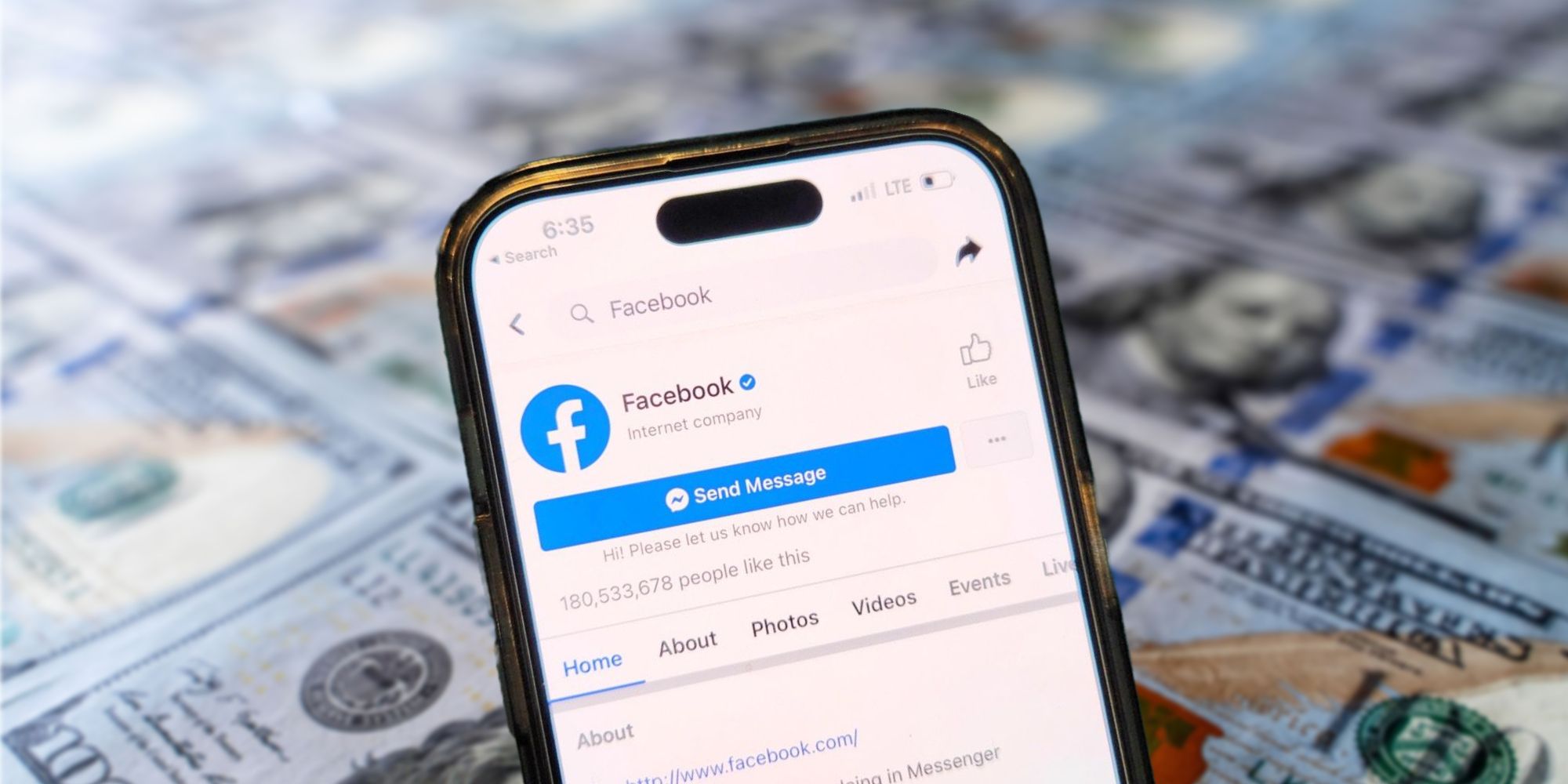 Facebook is shown on a smartphone in front of a background with 100 dollar bills