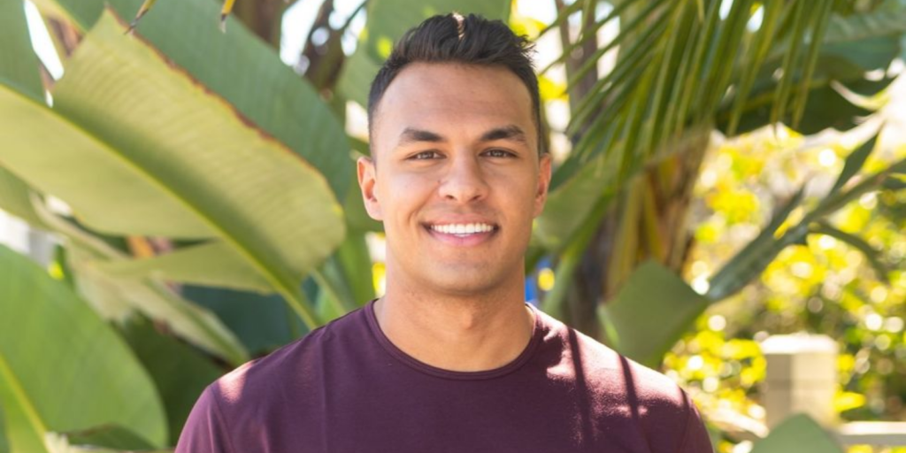 Aaron Clancy on Bachelor in Paradise in front of palm trees