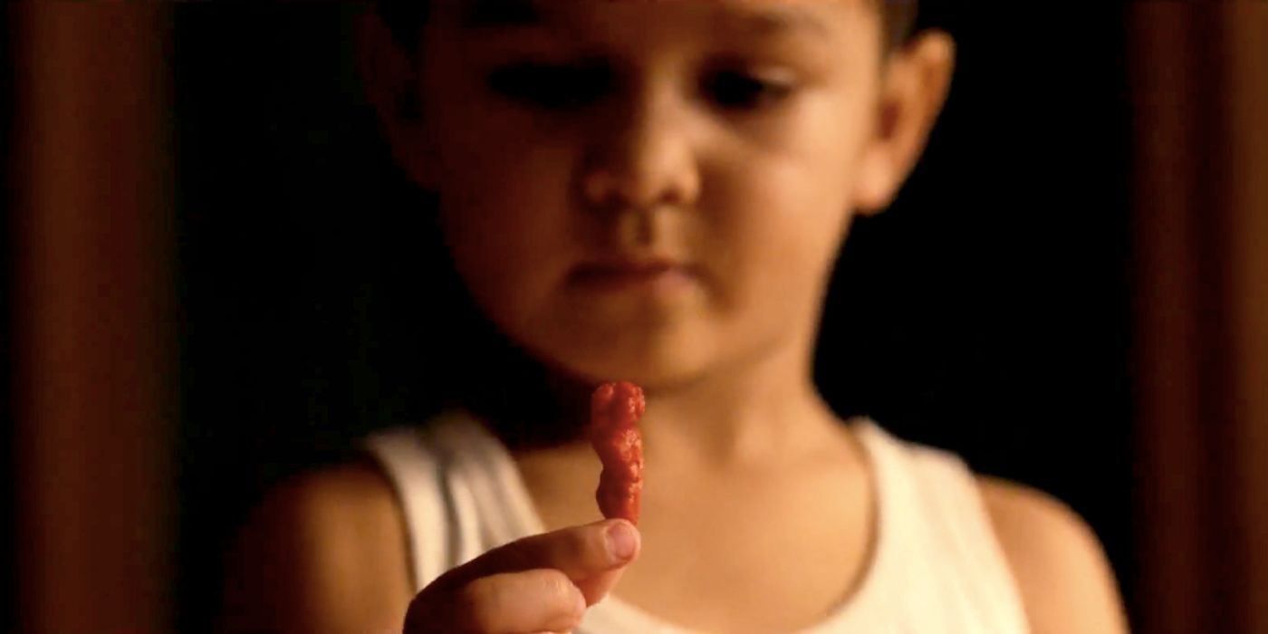 Child Holding a Cheeto in Flamin Hot