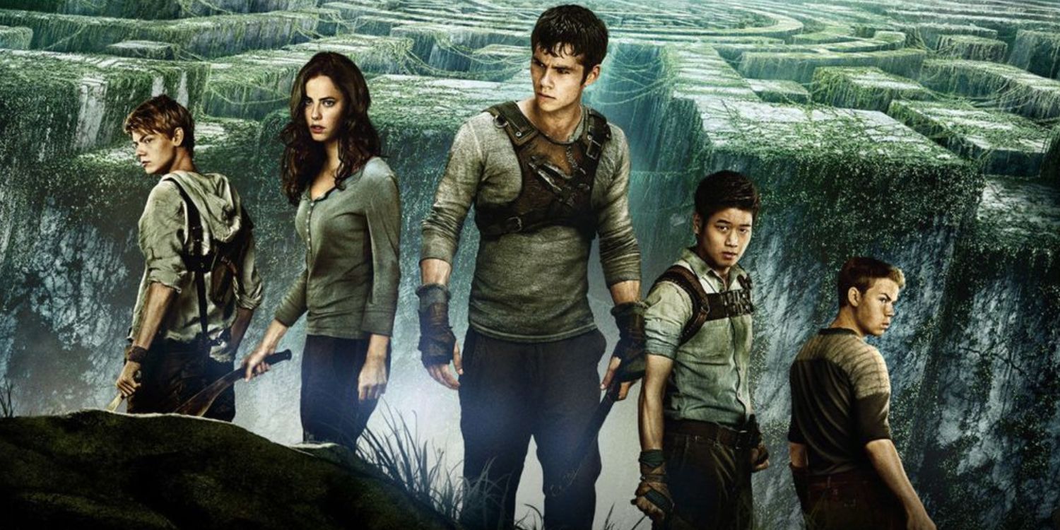 An image of the Maze Runner cast standing together in front of the maze