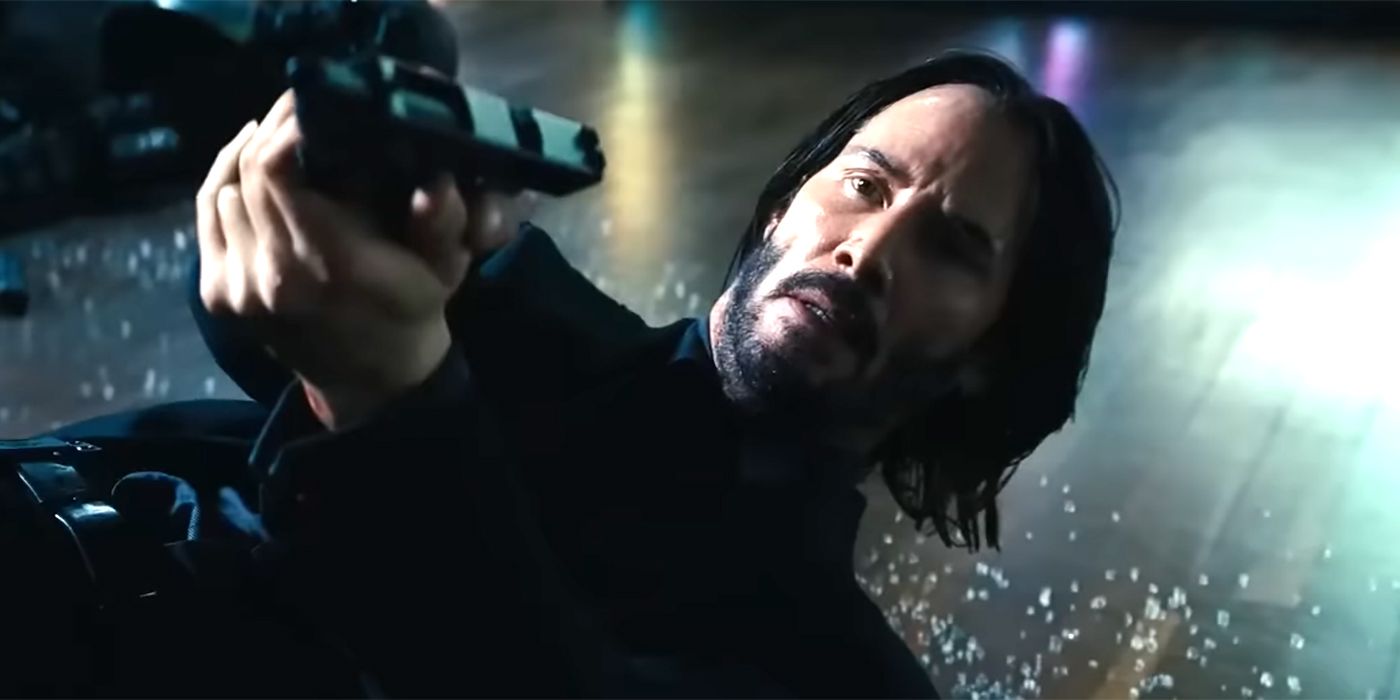 Keanu Reeves in John Wick Chapter 4 on the ground pointing a gun