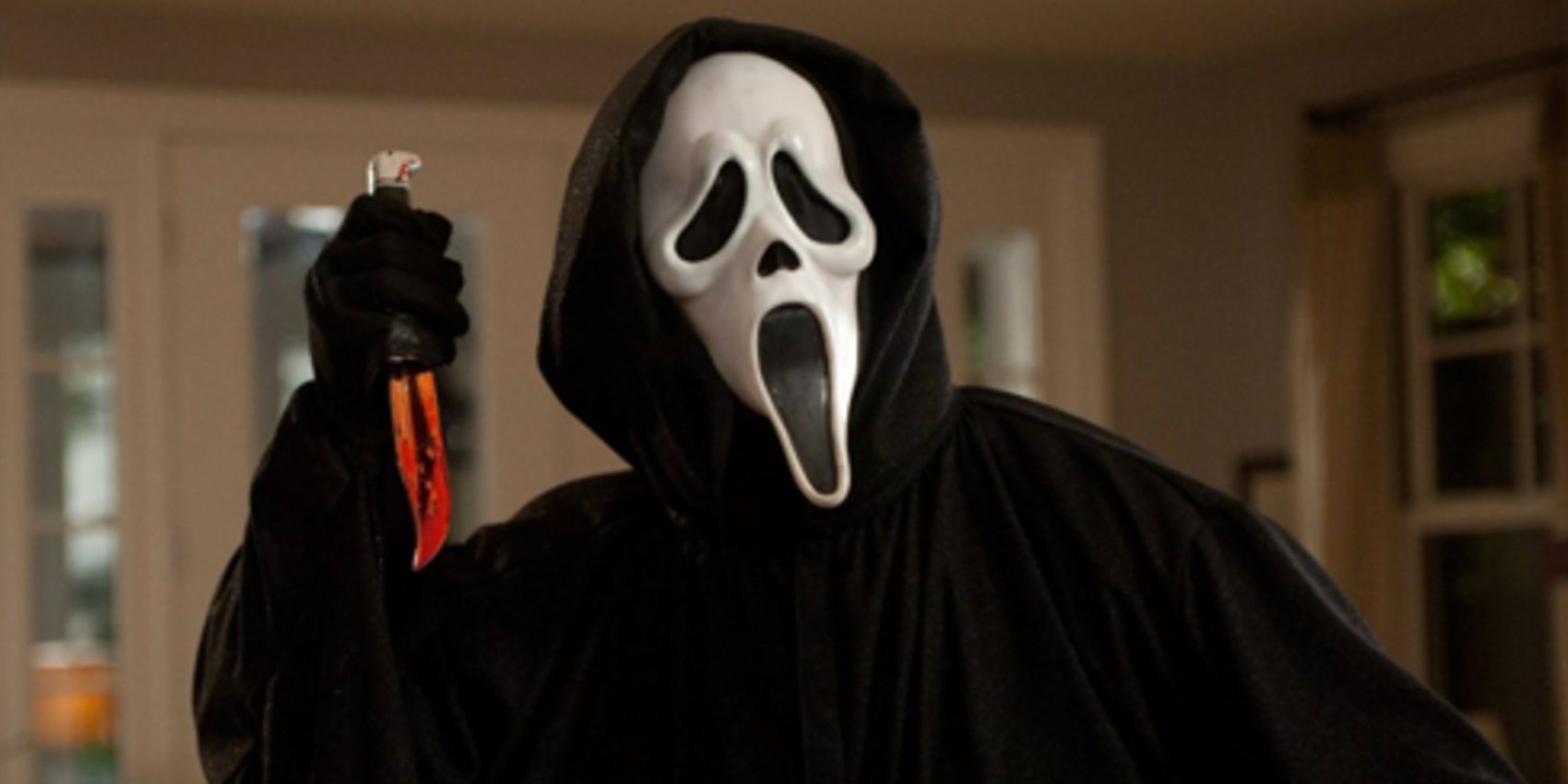The Ghostface killer raises a bloody knife in Scream.