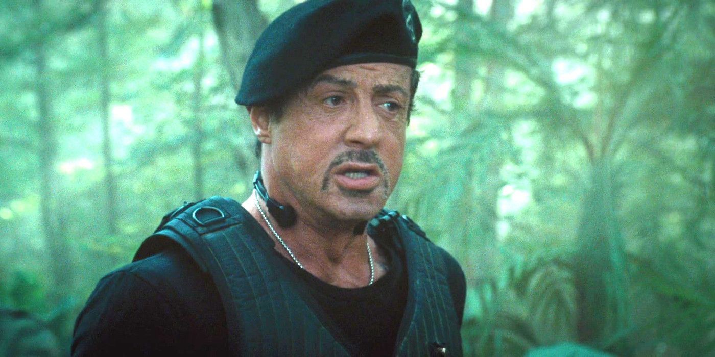 Sylvester Stallone in The Expendables wearing a flak jacket and beret in the jungle