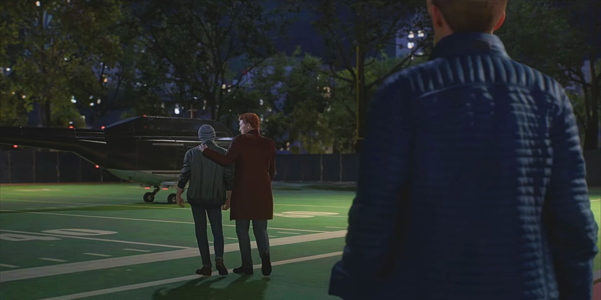 Peter observa mientras Harry y Norman caminan hacia un helicóptero estacionado en el campo de fútbol de la escuela secundaria en una captura de pantalla de Marvel's Spider-Man 2. La mano de Norman está sobre el hombro de Harry.