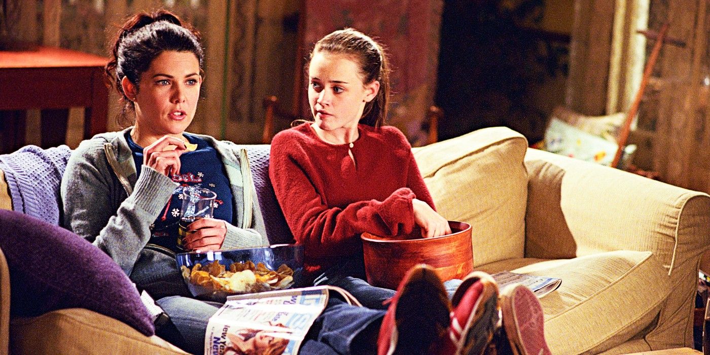 Lorelai y Rory de Gilmore Girls comiendo bocadillos mientras miran televisión.
