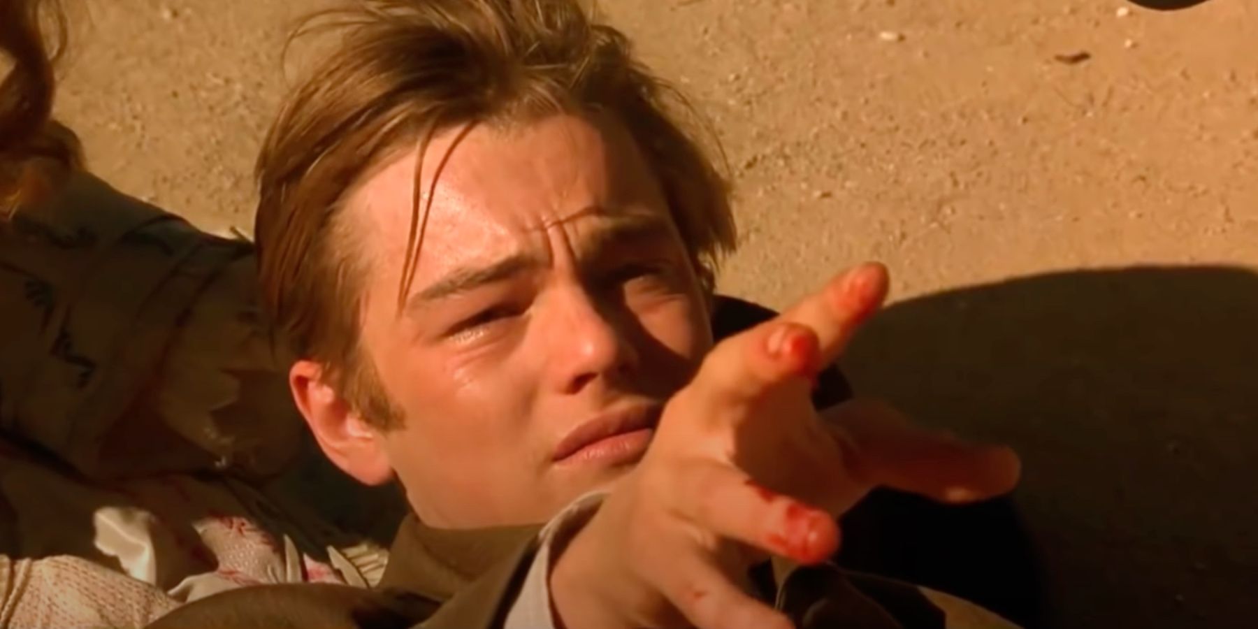 Un Leonardo DiCaprio angustiado extendiendo sus dedos ensangrentados en The Quick and the Dead.