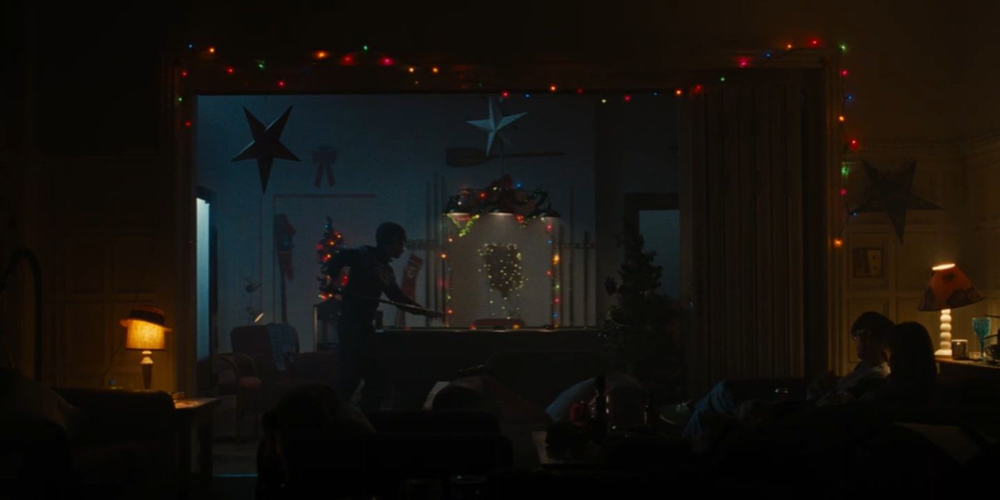 Oliver jugando al billar solo rodeado de adornos navideños en Saltburn