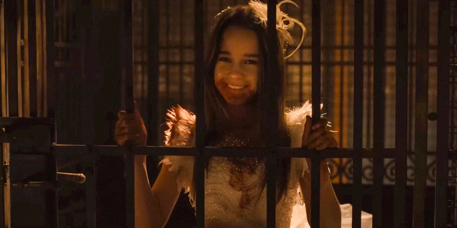 Abigail sonriendo mientras está encerrada en una jaula en Abigail 