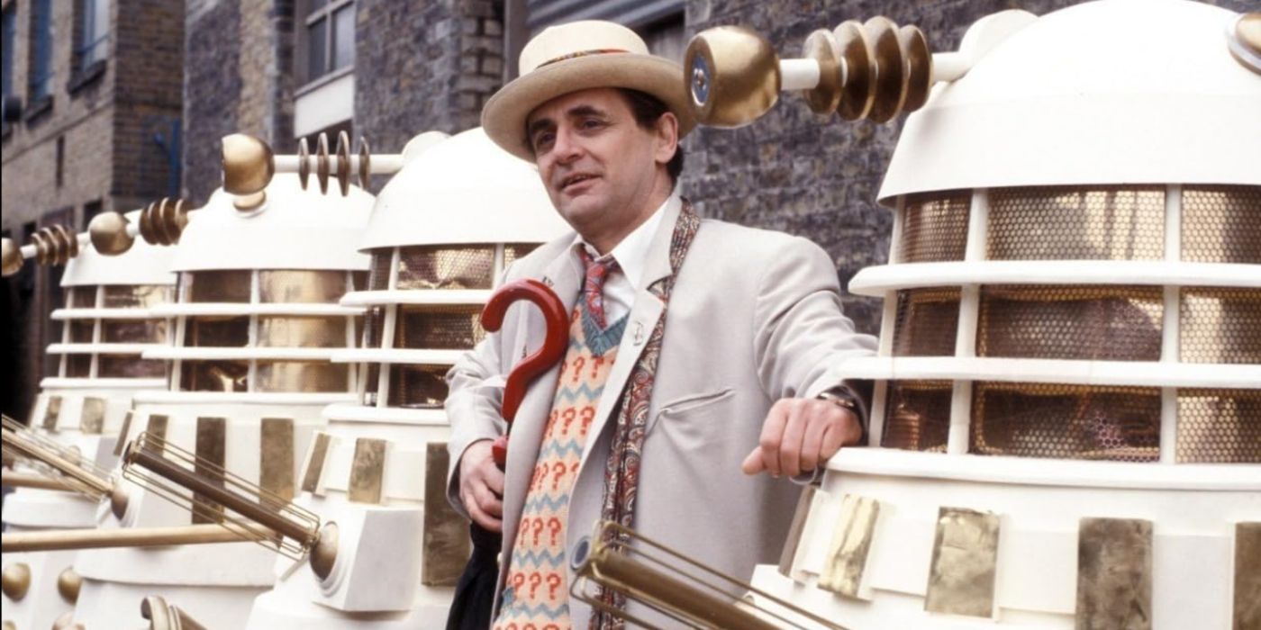 Sylvester McCoy como el Séptimo Doctor, posando con varios Daleks