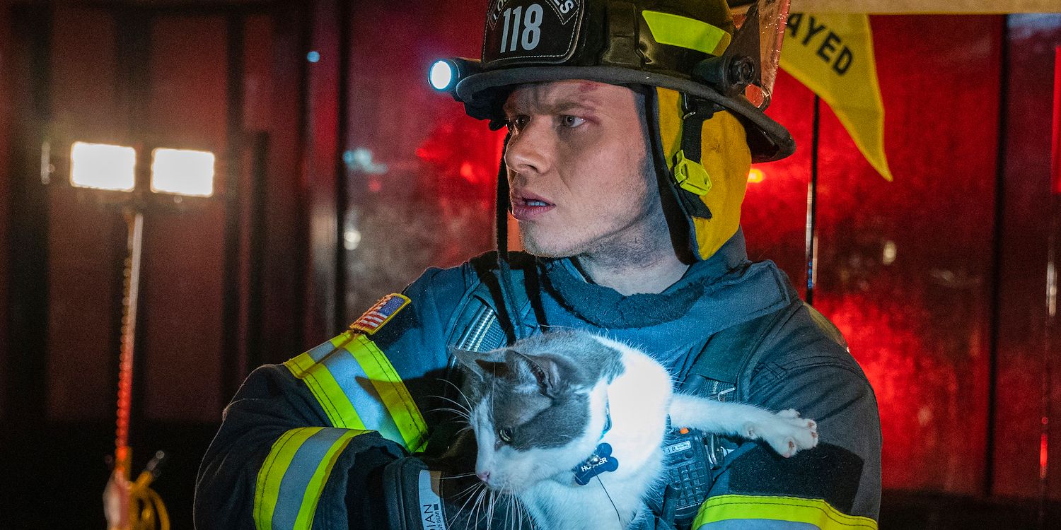 Buck (Oliver Stark) con su uniforme de bombero, sosteniendo un gato en el 9-1-1.