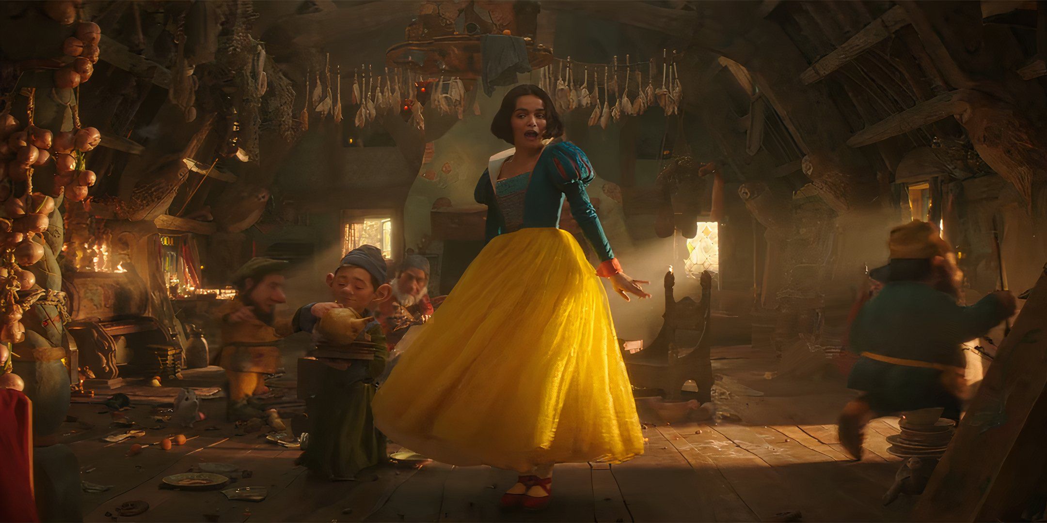 Rachel Zegler como Blancanieves cantando y bailando con los enanos en Blancanieves